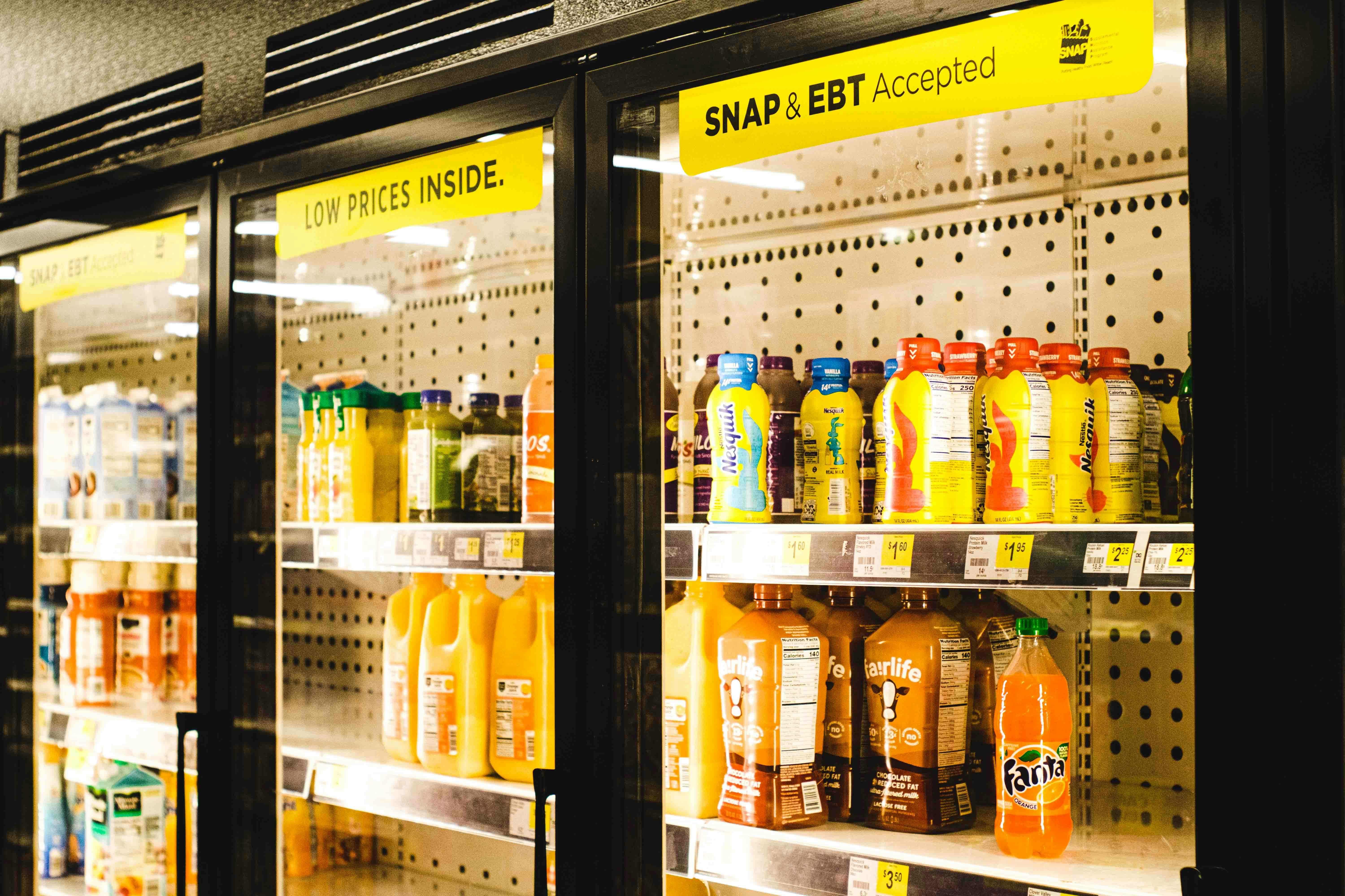 a display case in a grocery store filled with orange juice