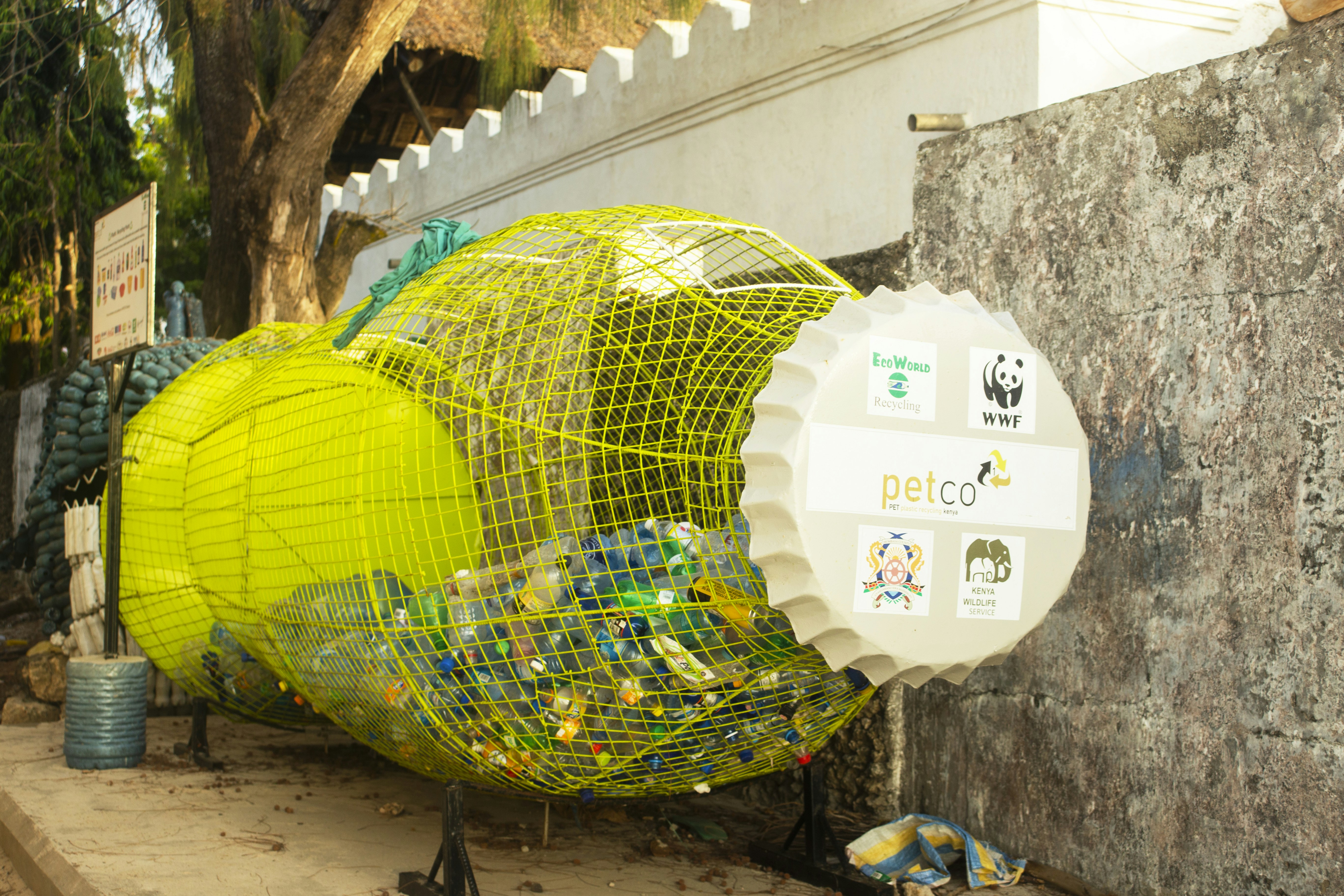 a yellow bird cage sitting on the side of a building