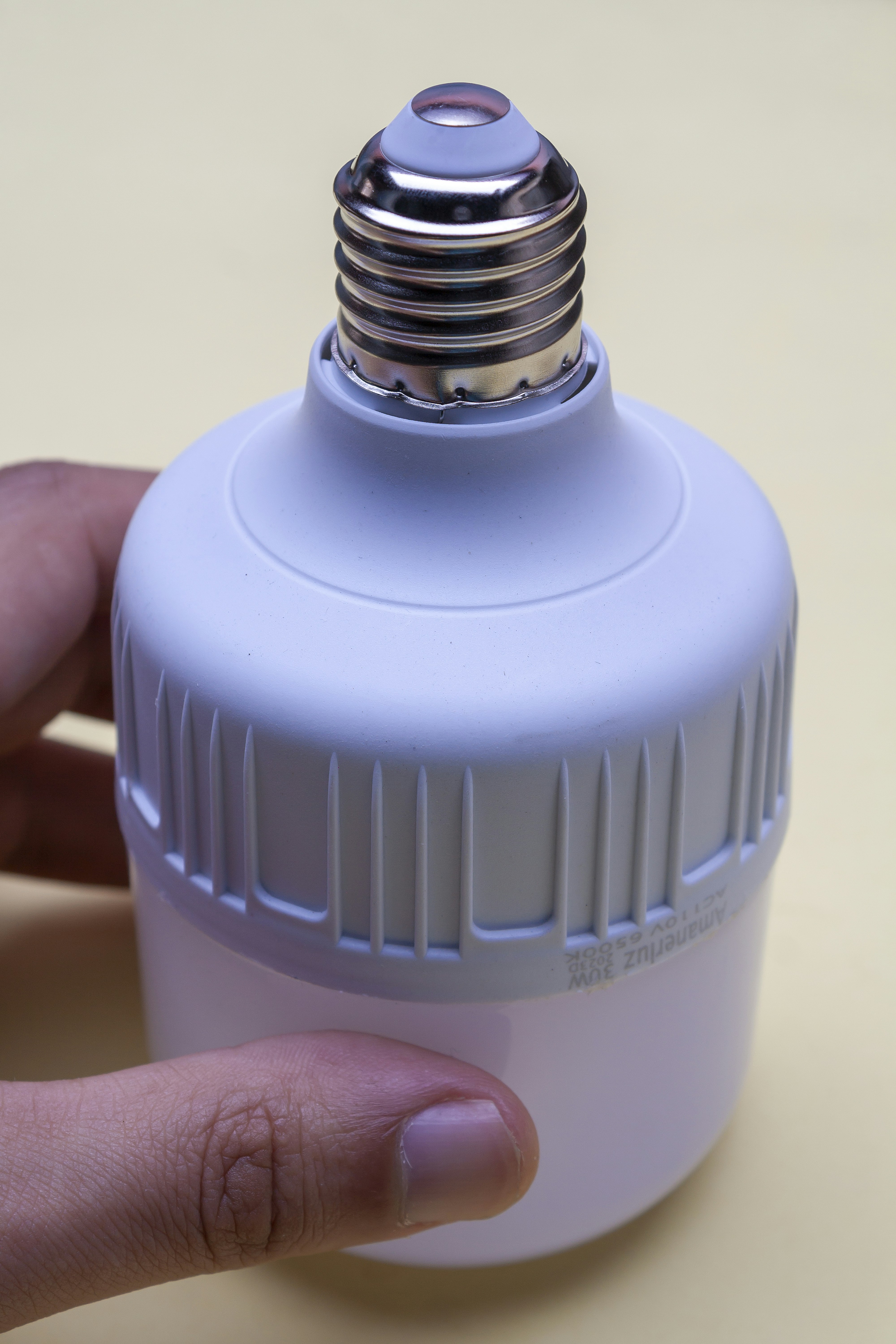 A person is holding a small light bulb