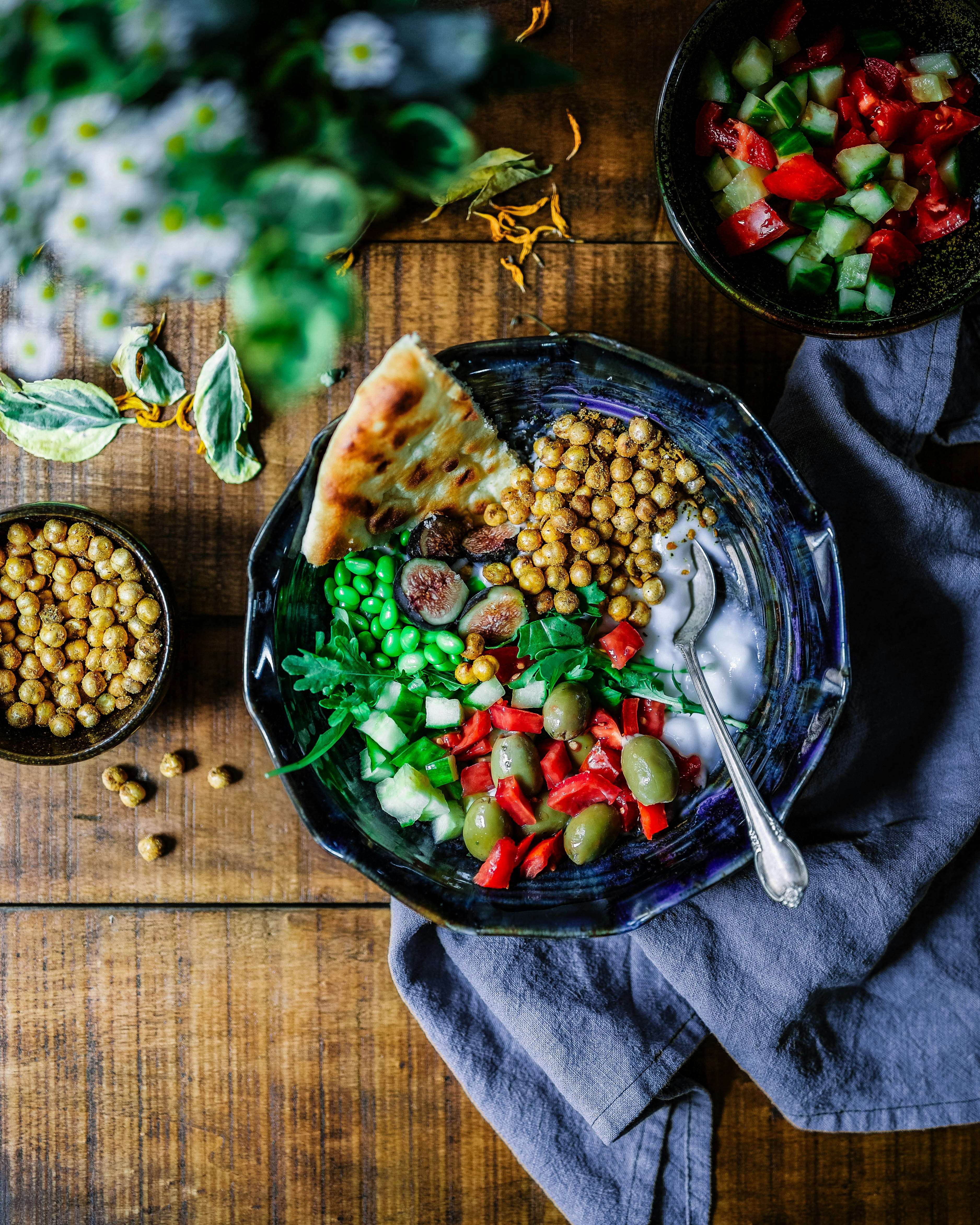 Yogurt Bowl by Gone Greenish silver spoon on black ceramic bowl with vegetables