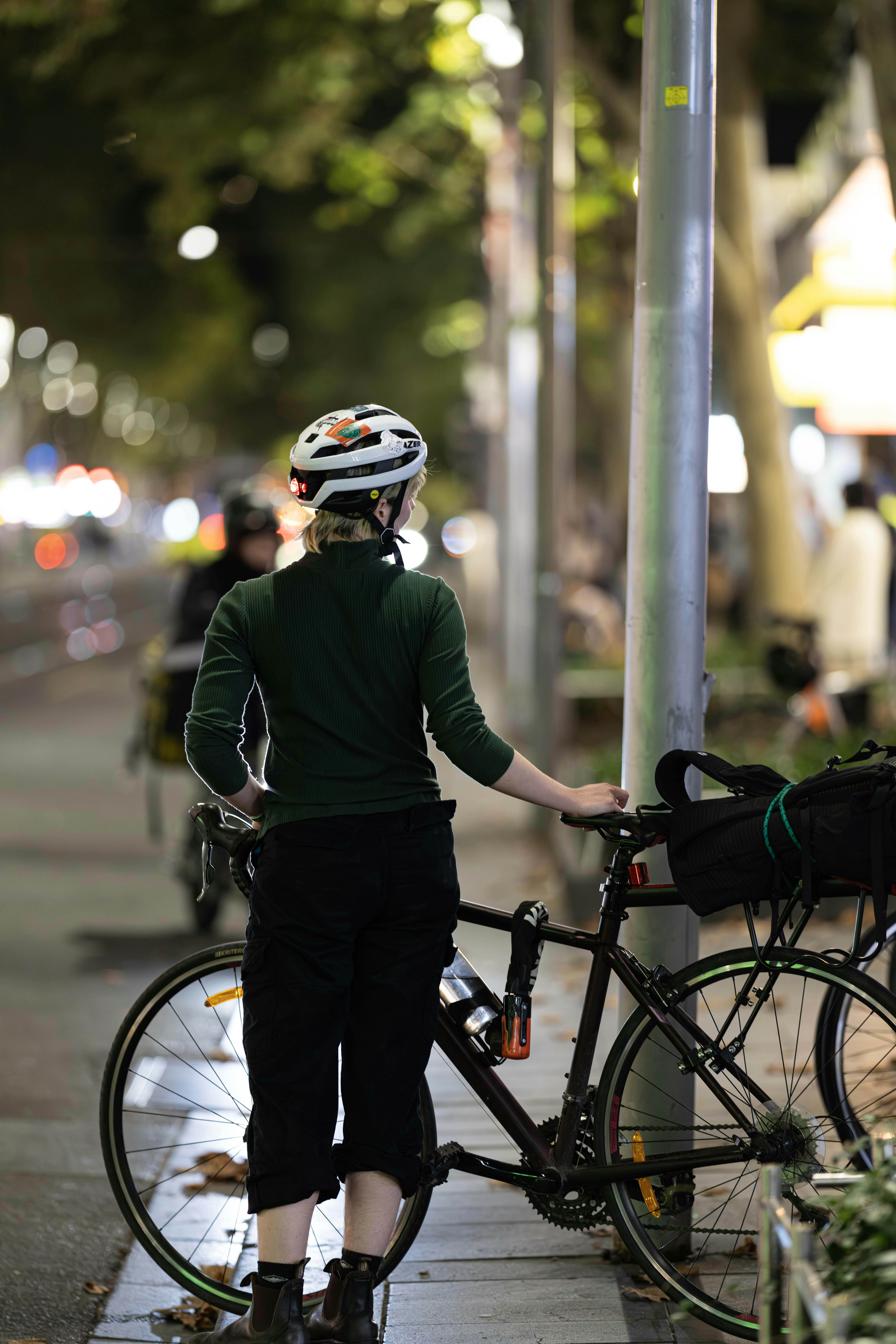Cyclist standing with bike on a dark city street
