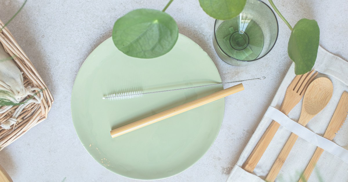 a green plate with a fork, knife, and napkin on it