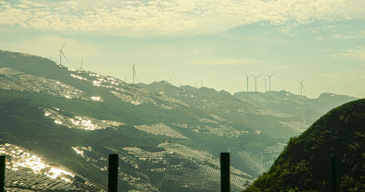 Wind turbines on distant mountains under a cloudy sky
